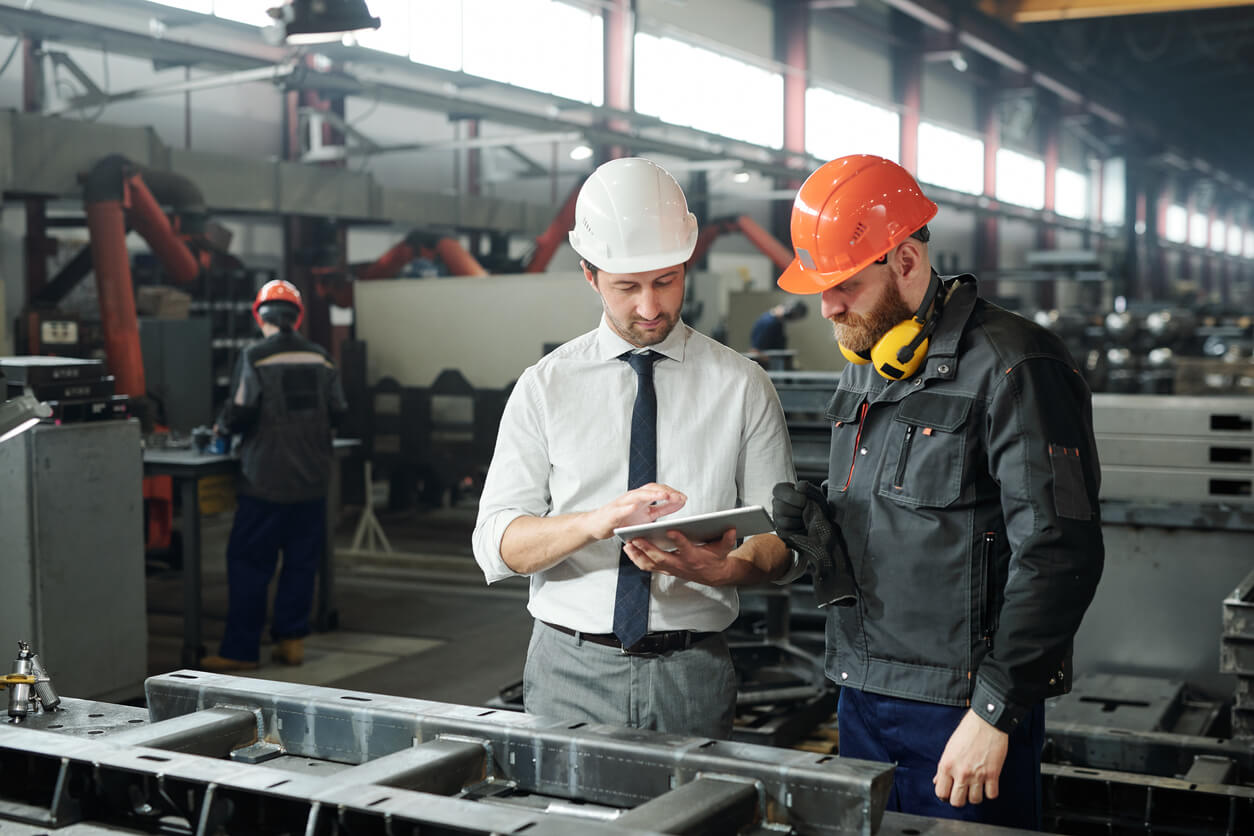 Two men in hard hats in manufacturing plant