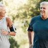 Elderly couple enjoys being active together by running through nature