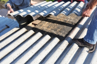 Workers remove asbestos roofing