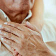 Elderly man with hands on his chest