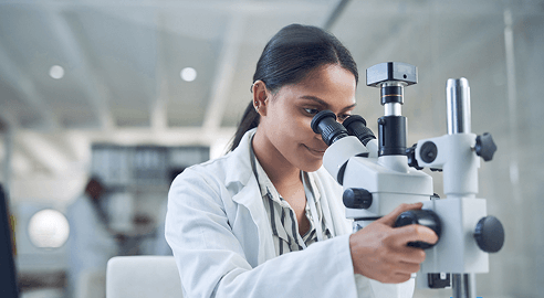 scientist looking through microscope