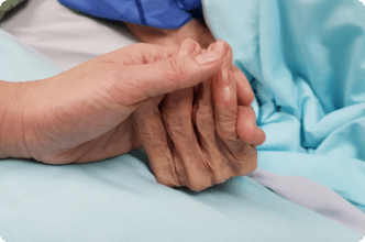 Loved ones holding hands in hospital room