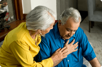 Wife comforts husband who is dealing with chest pain from mesothelioma