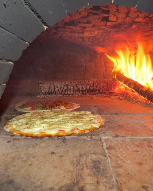Marguerita pizza baking in the wood oven