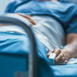 Patient in blue lying in hospital bed